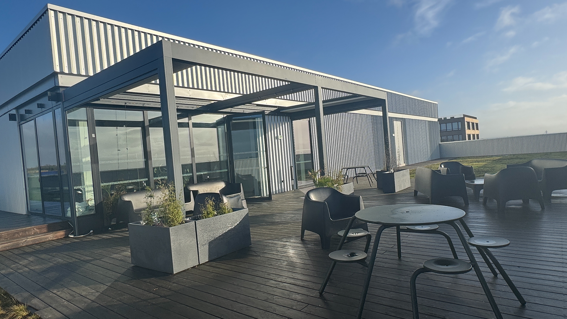 Rooftop ensoleillé avec tables, chaises, plantes et vue bâtiment Le Lieu Creative Seeds Rennes