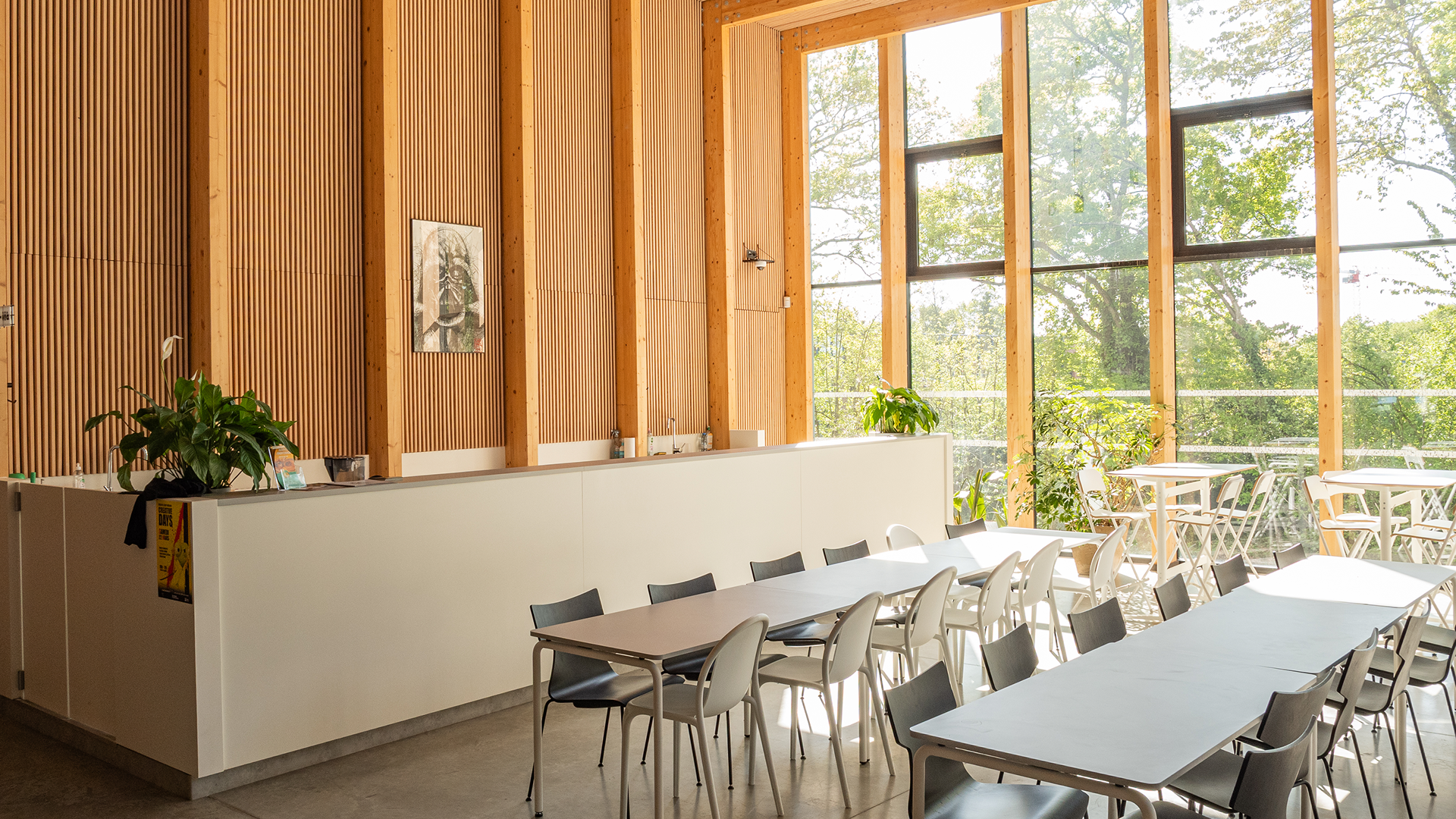 Grand hall spacieux avec tables, chaises et poutres apparentes modernes au Lieu Creative Seeds