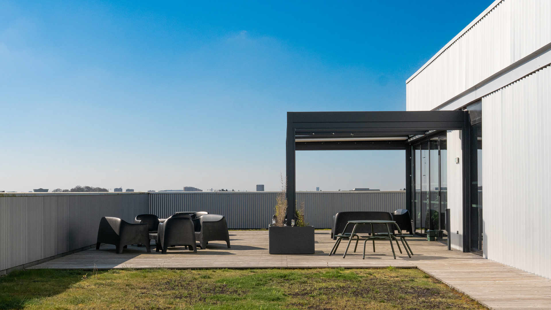 Rooftop avec pergola, tables et bancs sous ciel bleu à Creative Seeds Cesson-Sévigné
